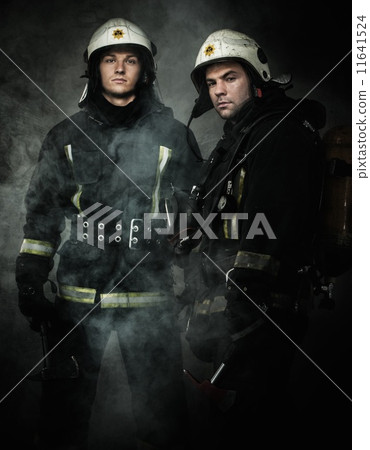 Two firefighters with axes in a smoke 11641524