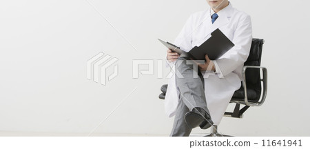 A man in a white robe looking at documents A man in a white robe looking at documents 11641941
