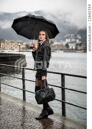 Woman walking with umbrella under the rain Woman walking with umbrella under the rain 11642354