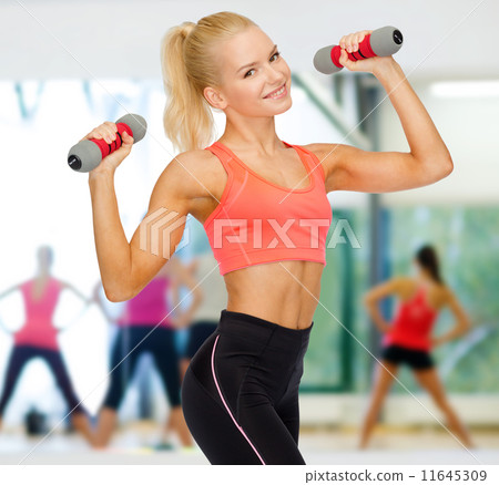 smiling beautiful sporty woman with dumbbells 11645309