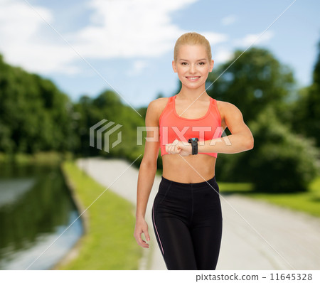 smiling woman with heart rate monitor on hand 11645328