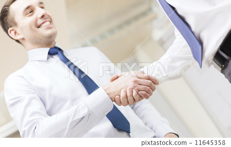 two businessmen shaking hands in office two businessmen shaking hands in office 11645358