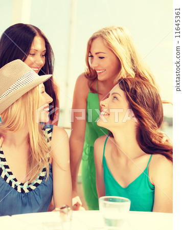 group of smiling girls in cafe on the beach 11645361