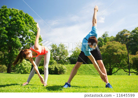 smiling couple stretching outdoors 11645599