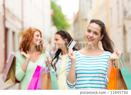 smiling teenage girls with shopping bags on street smiling teenage girls with shopping bags on street 11645730