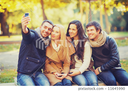 group of friends with photo camera in autumn park 11645990