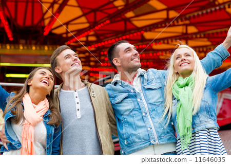 group of smiling friends in amusement park 11646035