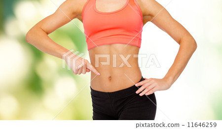 close up of woman pointing finger at her six pack 11646259