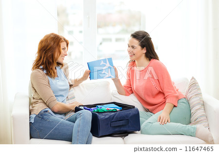 two smiling teenage girls with plane tickets two smiling teenage girls with plane tickets 11647465