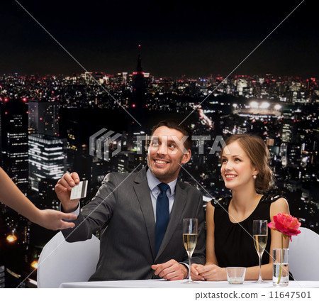 smiling couple paying for dinner with credit card smiling couple paying for dinner with credit card 11647501