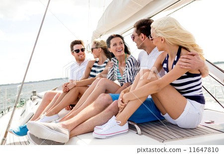 smiling friends sitting on yacht deck 11647810