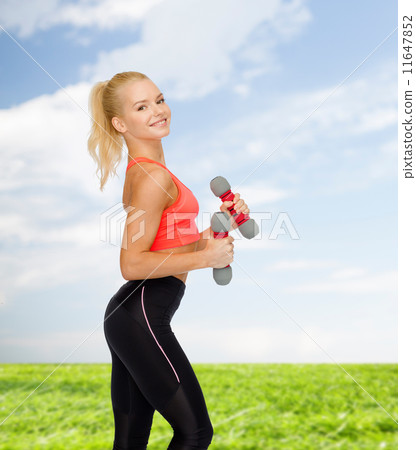 smiling beautiful sporty woman with dumbbells 11647852