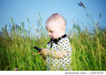 boy in grass call by phone 11653878