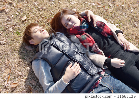 A young couple cuddling up in the autumn park A young couple cuddling up in the autumn park 11663129