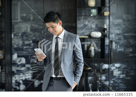 Young Asian business man using mobile phone 11665335