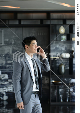 Young Asian business man talking with mobile phone Young Asian business man talking with mobile phone 11665336