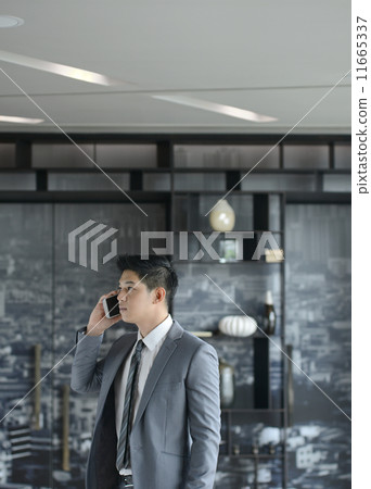 Young Asian business man talking with mobile phone Young Asian business man talking with mobile phone 11665337