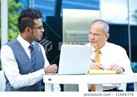 Young executive making presentation to senior executive on laptop Young executive making presentation to senior executive on laptop 11666376