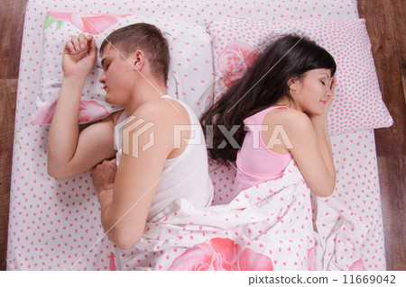 girl and guy turned away from each other, sleeping bed 11669042