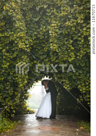 Newly married couple dancing at tunnel in trees 11670713