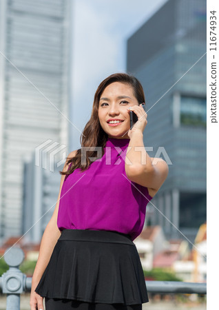 A young confident beautiful Financial Advsior connecting with her client on the mobile device/ phone A young confident beautiful Financial Advsior connecting with her client on the mobile device/ phone 11674934