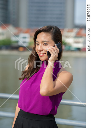 A young confident beautiful Financial Advsior connecting with her client on the mobile device/ phone 11674935