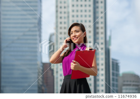 A young confident beautiful Financial Advsior connecting with her client on the mobile device/ phone A young confident beautiful Financial Advsior connecting with her client on the mobile device/ phone 11674936