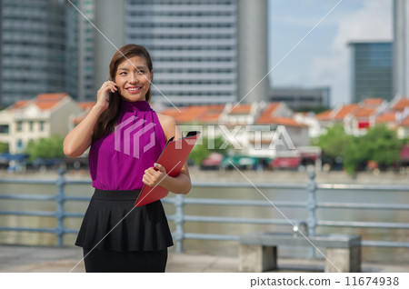 A young confident beautiful Financial Advsior connecting with her client on the mobile device/ phone A young confident beautiful Financial Advsior connecting with her client on the mobile device/ phone 11674938