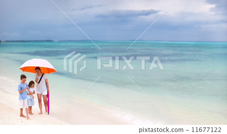 Family at beach on rainy day 11677122