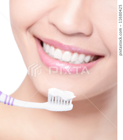 smiling woman cleaning teeth with toothbrush 11680425
