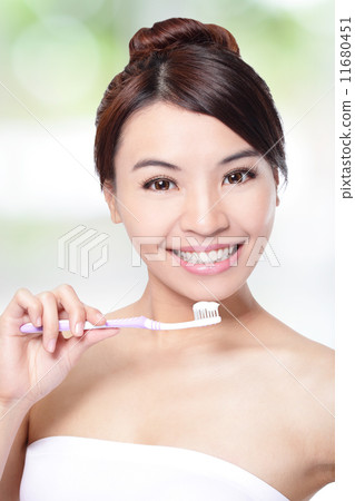 smiling woman cleaning teeth with toothbrush 11680451