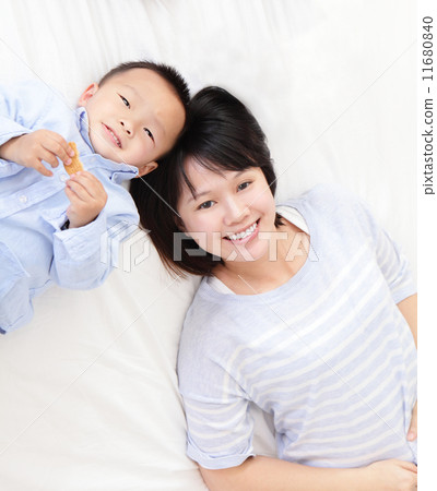 Happy mother and son lying on bed Happy mother and son lying on bed 11680840