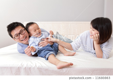 happy family playing on white bed 11680863