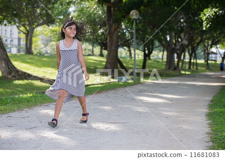 Happy Young asian girl walking and hopping in the park Happy Young asian girl walking and hopping in the park 11681083