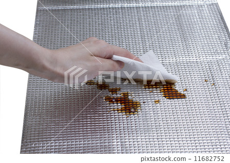 housewife's hand cleaning stained sauce on foil sheet 11682752