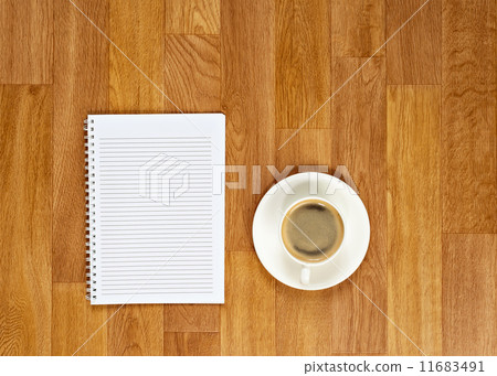 Blank notepad with office supplies and cup of coffee on wooden t 11683491