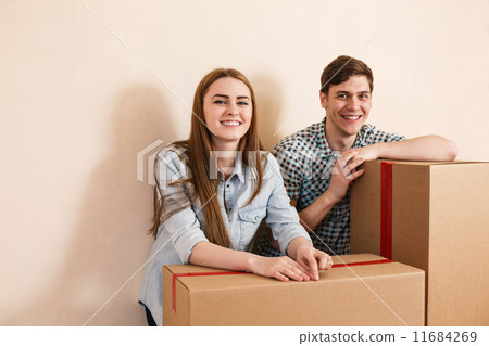 Smiling couple leaning on boxes 11684269