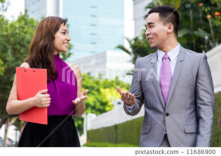 Asian business associates having a light-hearted discussion outdoors 11686900