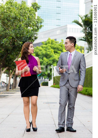 Asian young business associates having discussion while on the move Asian young business associates having discussion while on the move 11686901