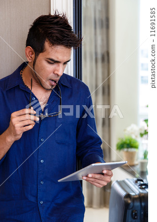 Asian man using digital tablet, contemplating. Asian man using digital tablet, contemplating. 11691585