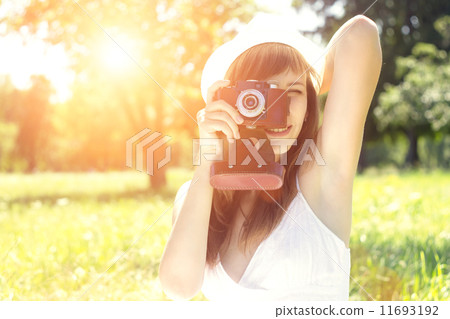 Young woman posing with old film camera in summer park 11693192