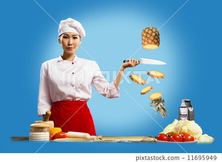 Asian female chef cuts pineapple Asian female chef cuts pineapple 11695949