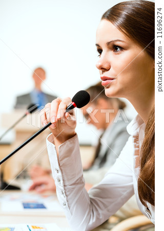 Business woman speaks into a microphone Business woman speaks into a microphone 11696274