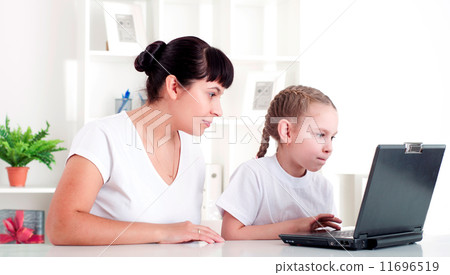 Mom and daughter are working together for a laptop 11696519
