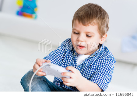 Boy playing on a game console 11696845