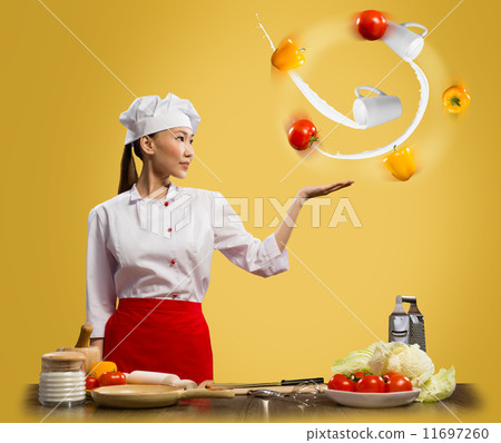 Asian woman chef juggling with vegetables Asian woman chef juggling with vegetables 11697260