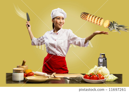Asian female chef cuts pineapple Asian female chef cuts pineapple 11697261