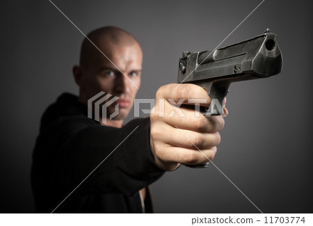 man shooting gun isolated on gray background. focus on gun 11703774