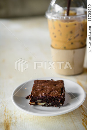 Fresh Homemade Chocolate Brownie and ice coffee against a backgr Fresh Homemade Chocolate Brownie and ice coffee against a backgr 11703920