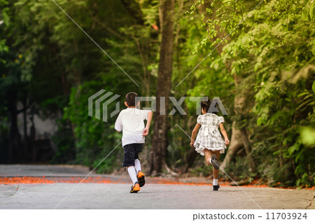 Back of Asian children running in to the park 11703924
